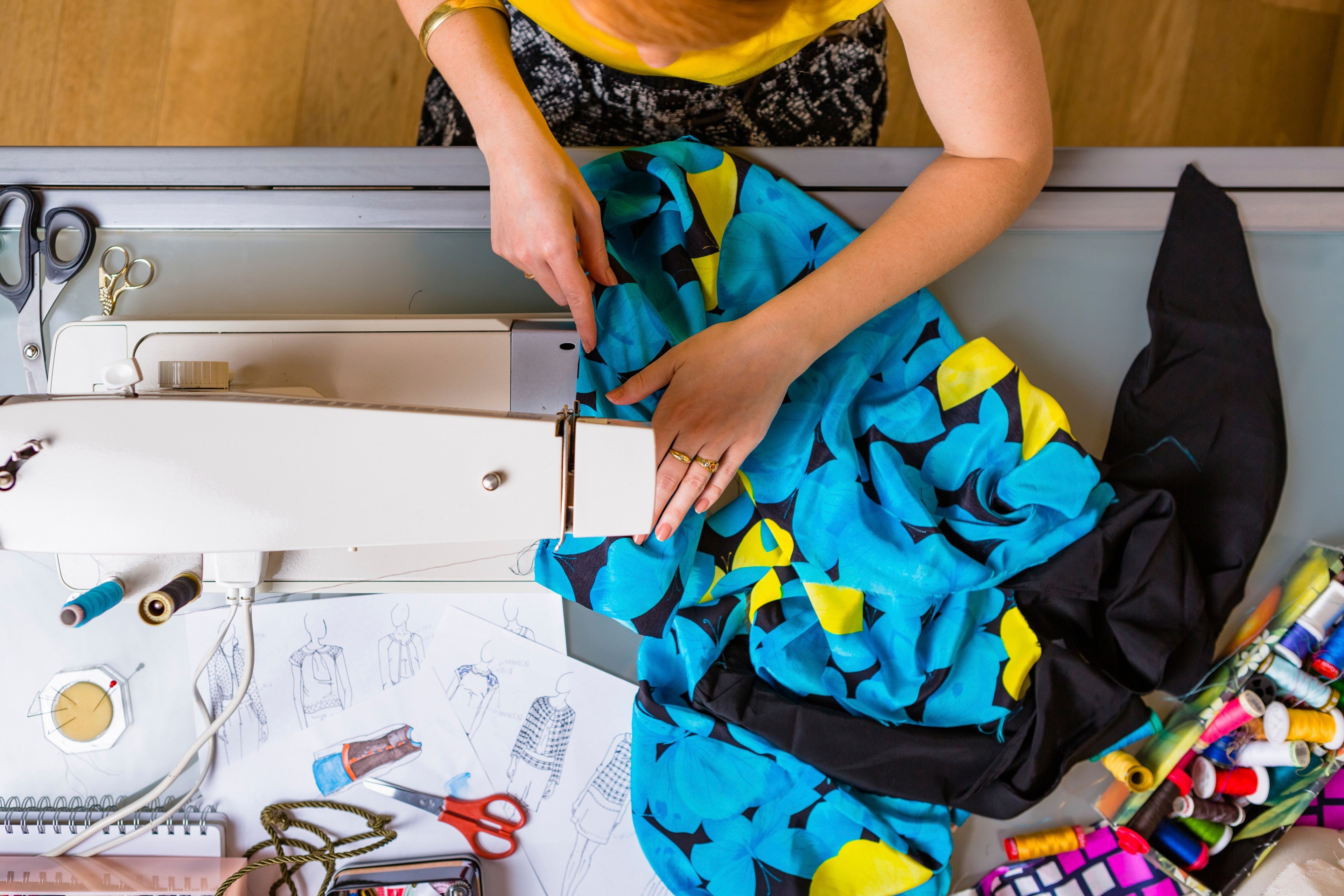 View of a person working on a sewing machine to make apparel
