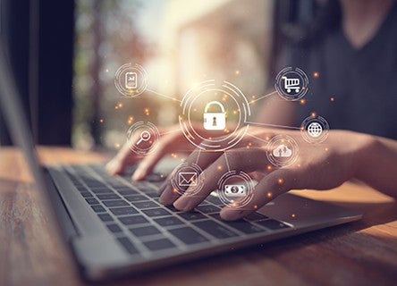 Hands typing on a laptop with digital security and connectivity icons overlaid, illustrating software supply chain risk management and open source security.